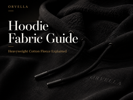 Luxury black ORVELLA hoodie close-up showing heavyweight cotton fleece fabric, tonal branding and drawcord details for a hoodie fabric guide.