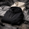 Luxury hoodie comparison featuring the black ORVELLA Signature Hoodie with premium neutral hoodies and minimalist accessories.