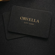Black gift card with 'Orvella' branding on a dark textured surface.