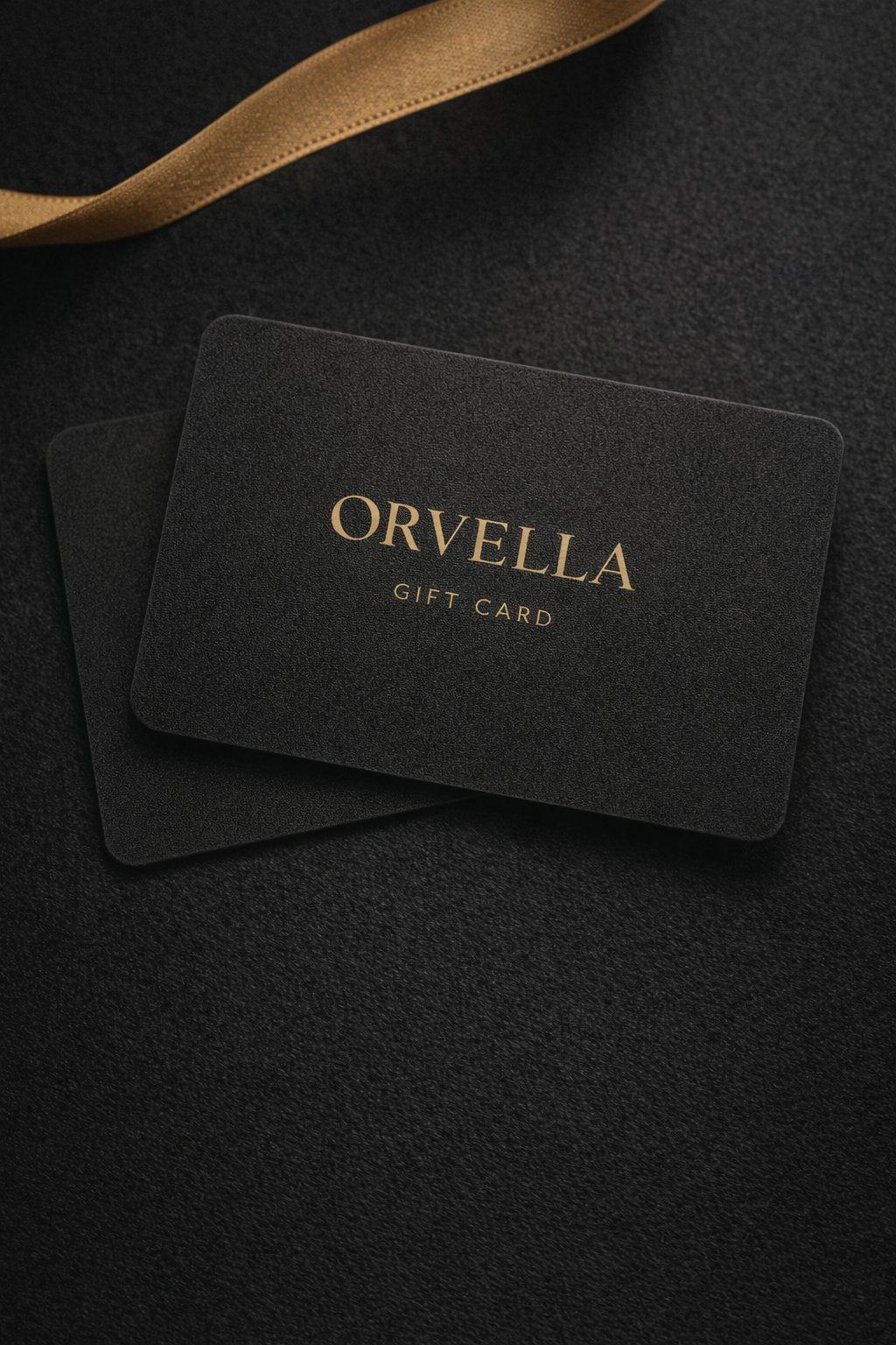 Black gift card with 'Orvella' branding on a dark textured surface.