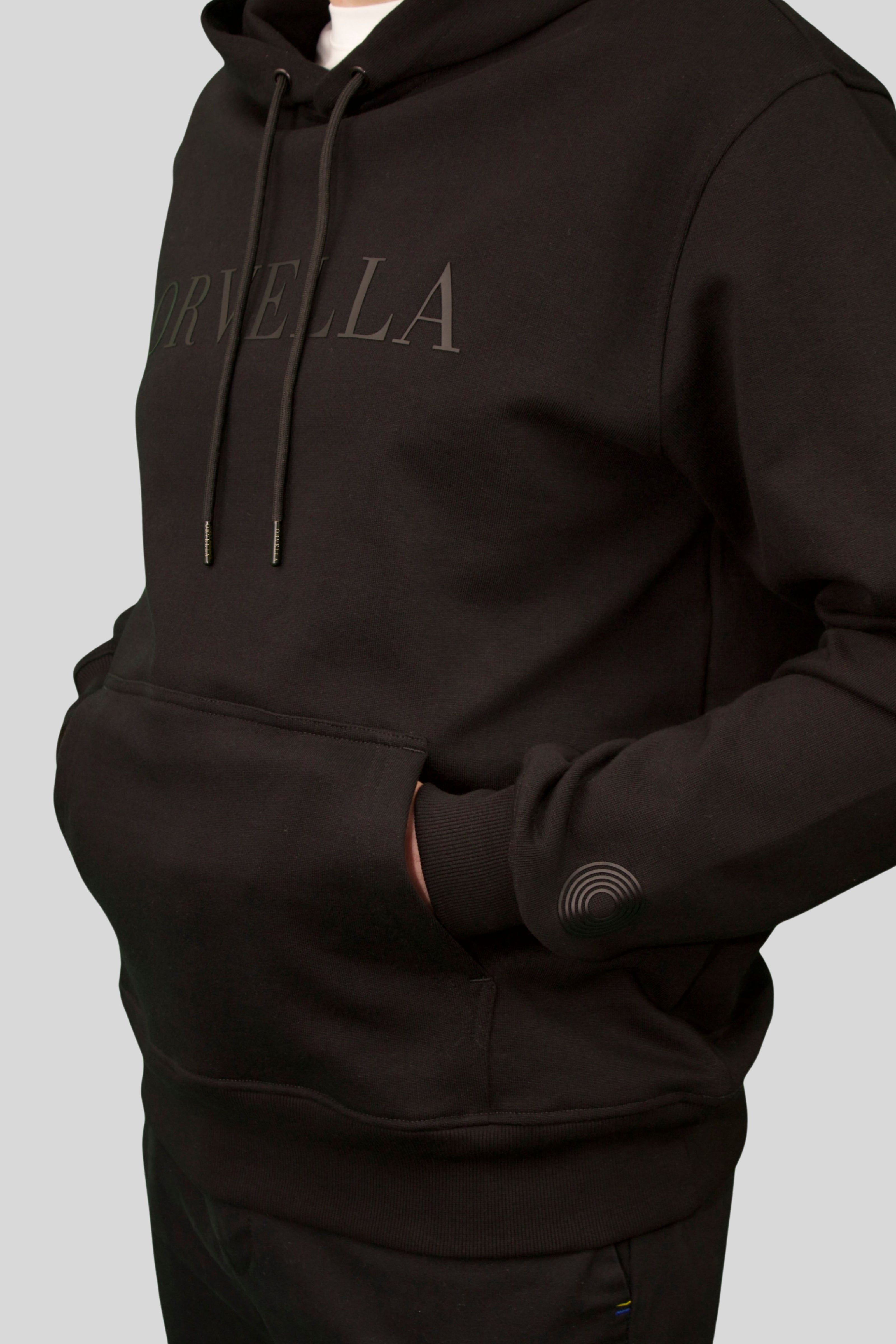 Luxury black ORVELLA hoodie close-up with tonal logo, drawstrings and kangaroo pocket