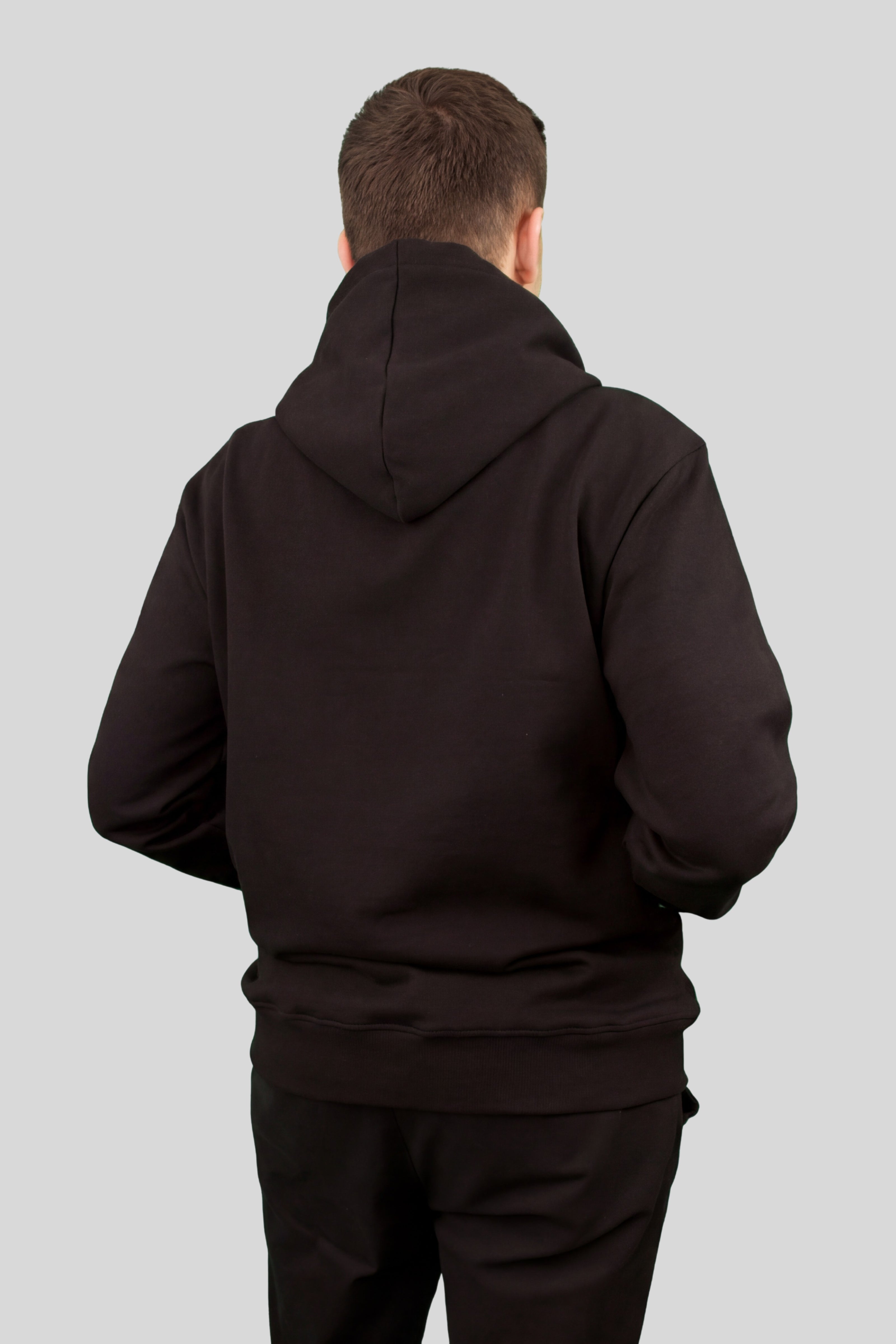 Rear view of male model wearing black ORVELLA luxury hoodie with clean premium fit