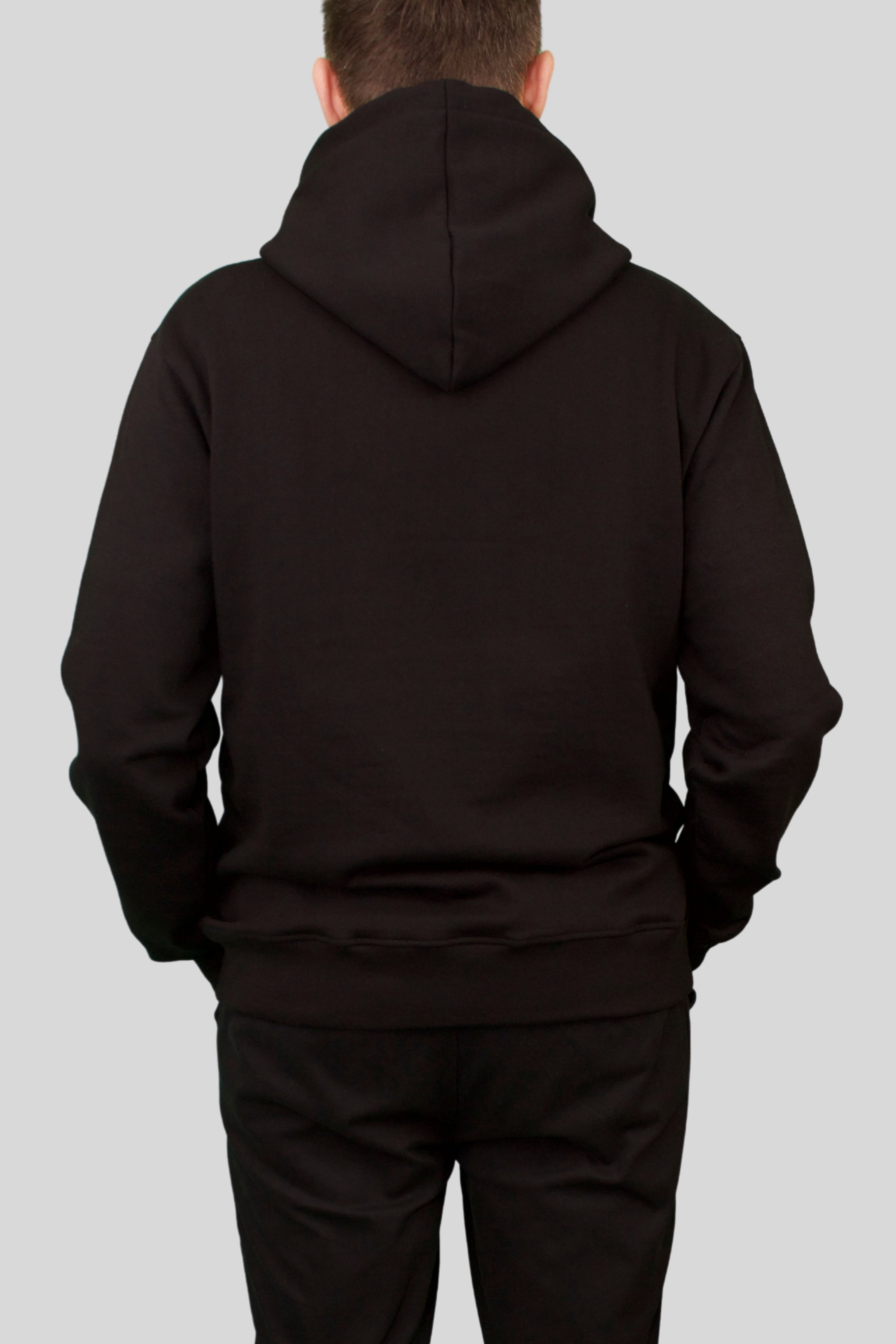 Rear view of male model wearing black ORVELLA luxury hoodie with structured hood and premium fit