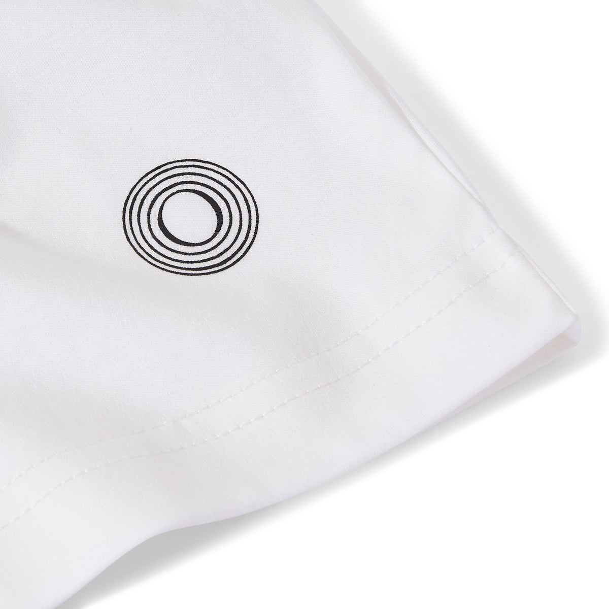 Close-up of the Billionaire by ORVELLA white luxury T-shirt sleeve, showing the signature circular emblem, clean stitching, and smooth premium fabric detail.